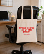 My soul is empty like my bank account – Stoffbeutel mit Spruch beige, am Bürostuhl im Büro