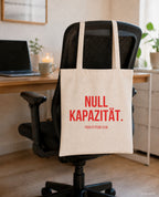Null Kapazität. – Stoffbeutel mit Spruch beige, am Bürostuhl im Büro
