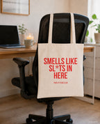 Smells like sl*ts in here – Stoffbeutel mit Spruch beige, am Bürostuhl im Büro