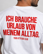 ICH BRAUCHE URLAUB VON MEINEM ALLTAG. – Unisex Statement T-Shirt Weiß mit rotem Backprint | lustiges Sprüche Shirt