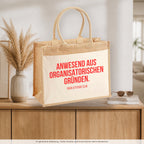 Anwesend aus organisatorischen Gründen. – Jutetasche mit Spruch, auf dem Sideboard im Flur