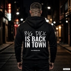 Big Dick is Back in Town – schwarzer Hoodie mit weißem Backprint, Herren in der Stadt bei Nacht