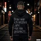 Brav war ich letztes Jahr. Hat nix gebracht – schwarzer Hoodie mit weißem Backprint, Herren in der Stadt bei Nacht