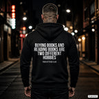 Buying books and reading books are two different hobbies – schwarzer Hoodie mit weißem Backprint, Herren in der Stadt bei Nacht