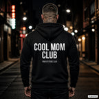 COOL MOM CLUB – schwarzer Hoodie mit weißem Backprint, Herren in der Stadt bei Nacht