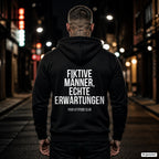 Fiktive Männer, echte Erwartungen – schwarzer Hoodie mit weißem Backprint, Herren in der Stadt bei Nacht