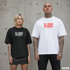 ALL SUGAR NO DADDY – Oversize Shirt mit Spruch auf der Brust, Paar in Schwarz und Weiß vor Betonwand