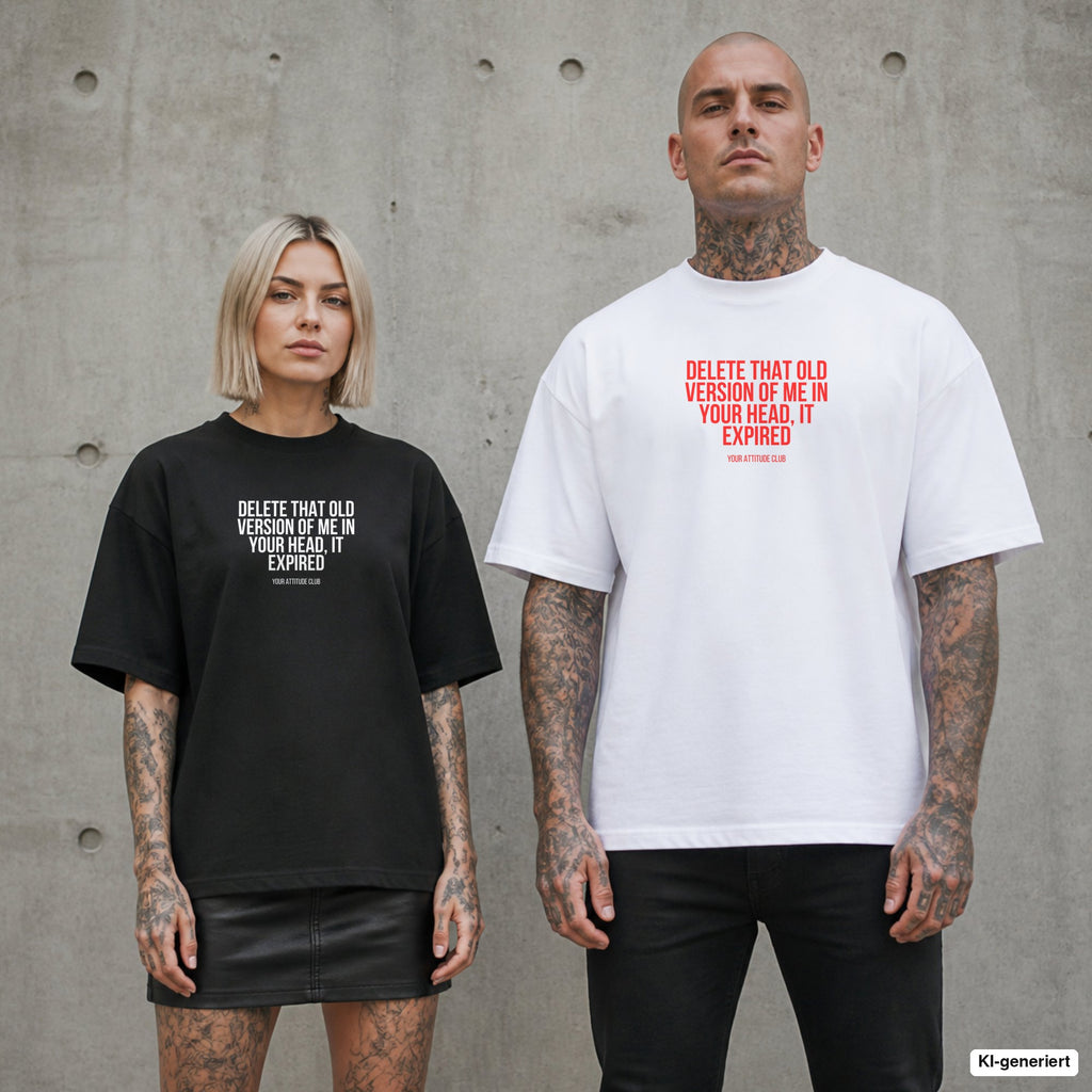 DELETE THAT OLD VERSION OF ME IN YOUR HEAD, IT EXPIRED – Oversize Shirt mit Spruch auf der Brust, Paar in Schwarz und Weiß vor Betonwand