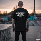 KISS ME FIRST WE’LL FIGURE THINGS OUT LATER – schwarzes Oversize T-Shirt mit weißem Backprint, Herren im Skatepark