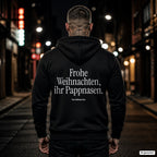 Frohe Weihnachten, ihr Pappnasen – schwarzer Hoodie mit weißem Backprint, Herren in der Stadt bei Nacht