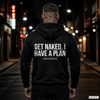 Get naked, I have a plan – schwarzer Hoodie mit weißem Backprint, Herren in der Stadt bei Nacht