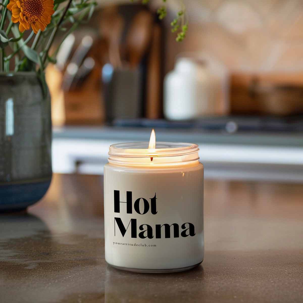 Duftkerze im transparenten Glas mit Spruch „Hot Mama“ – handgemachte Sojawachs-Kerze von Your Attitude Club, brennend in der Küche