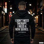I don’t need therapy. I need a new series. – schwarzer Hoodie mit weißem Backprint, Herren in der Stadt bei Nacht