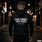 I have terrible taste in men – schwarzer Hoodie mit weißem Backprint, Herren in der Stadt bei Nacht