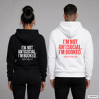 I’m not antisocial. I’m booked. – Hoodie mit Backprint, Frau in Schwarz und Mann in Weiß