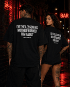 I’M THE LESSON HIS MOTHER WARNED HIM ABOUT – schwarzes Oversize Unisex Shirt, weißer Backprint, freches Spruchshirt, Sarkasmus, schwarzer Humor