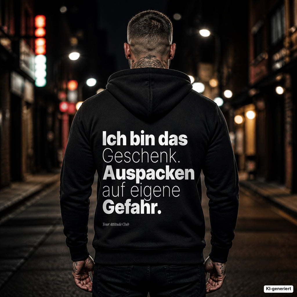 Ich bin das Geschenk. Auspacken auf eigene Gefahr – schwarzer Hoodie mit weißem Backprint, Herren in der Stadt bei Nacht