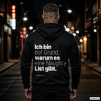 Ich bin der Grund, warum es eine Naughty List gibt – schwarzer Hoodie mit weißem Backprint, Herren in der Stadt bei Nacht