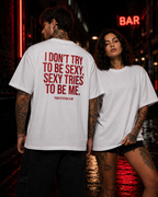 I DON’T TRY TO BE SEXY, SEXY TRIES TO BE ME – schwarzes Oversize Unisex Shirt, weißer Backprint, lustiges Statement Shirt, freches Streetwear Shirt