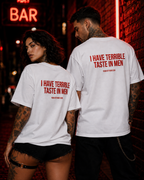 I HAVE TERRIBLE TASTE IN MEN – weißes Unisex Oversize Shirt mit rotem Backprint, lustiges Statement T-Shirt, Dating Humor, frecher Spruch, Geschenk