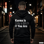 Karma Is Only a Bitch If You Are – schwarzer Hoodie mit weißem Backprint, Herren in der Stadt bei Nacht