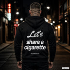 Let’s Share a Cigarette – schwarzer Hoodie mit weißem Backprint, Herren in der Stadt bei Nacht