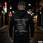 Meine Familie ist wie Lametta: glänzt, nervt, ist überall – schwarzer Hoodie mit weißem Backprint, Herren in der Stadt bei Nacht