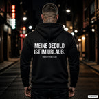 Meine Geduld ist im Urlaub – schwarzer Hoodie mit weißem Backprint, Herren in der Stadt bei Nacht