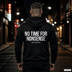 No time for nonsense – schwarzer Hoodie mit weißem Backprint, Herren in der Stadt bei Nacht