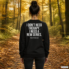 I don’t need therapy. I need a new series. – schwarzer Pullover mit weißem Backprint, Damen beim Herbstspaziergang