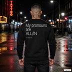 My pronouns are ALL-IN – schwarzer Pullover mit weißem Backprint, Herren in der Stadt bei Nacht