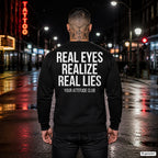 Real eyes realize real lies – schwarzer Pullover mit weißem Backprint, Herren in der Stadt bei Nacht