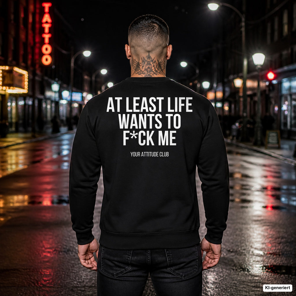 At least life wants to f*ck me – schwarzer Pullover mit weißem Backprint, Herren in der Stadt bei Nacht