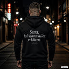 Santa, ich kann alles erklären – schwarzer Hoodie mit weißem Backprint, Herren in der Stadt bei Nacht