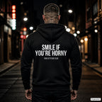Smile if you’re horny – schwarzer Hoodie mit weißem Backprint, Herren in der Stadt bei Nacht