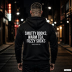 Smutty books, warm tea, fuzzy socks – schwarzer Hoodie mit weißem Backprint, Herren in der Stadt bei Nacht