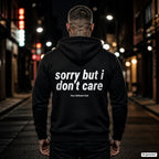 Sorry But I Don’t Care – schwarzer Hoodie mit weißem Backprint, Herren in der Stadt bei Nacht