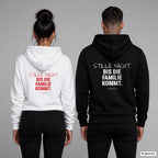 Stille Nacht. Bis die Familie kommt – Hoodie mit Backprint, Frau in Weiß mit rotem und Mann in Schwarz mit weißem Aufdruck