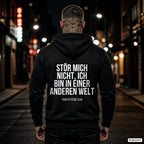 Stör mich nicht, ich bin in einer anderen Welt – schwarzer Hoodie mit weißem Backprint, Herren in der Stadt bei Nacht