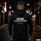WARNING: A LITTLE B*TCHY – schwarzer Hoodie mit weißem Backprint, Herren in der Stadt bei Nacht