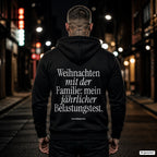 Weihnachten mit der Familie: mein jährlicher Belastungstest – schwarzer Hoodie mit weißem Backprint, Herren in der Stadt bei Nacht