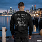 Meine Familie ist wie Lametta: glänzt, nervt, ist überall – schwarzer Weihnachtspullover mit weißem Backprint, Herren am Hafen