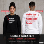 Ich bin das Geschenk. Auspacken auf eigene Gefahr – Weihnachtspullover wahlweise mit Front- oder Backprint, Paar vor Betonwand