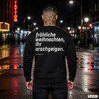 Fröhliche Weihnachten, ihr Arschgeigen – schwarzer Weihnachtspullover mit weißem Backprint, Herren in der Stadt bei Nacht