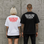 DAS KLINGT NACH EINEM PROBLEM FÜR MORGEN. – Oversize Shirt mit Spruch auf dem Rücken, Paar in Weiß und Schwarz vor Betonwand