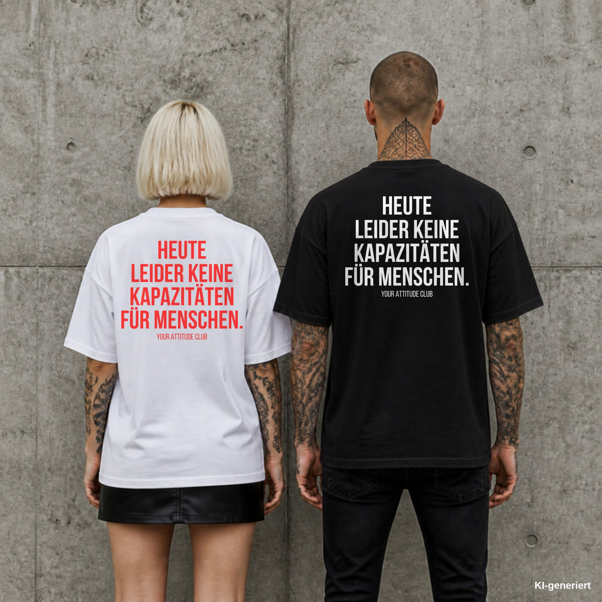 HEUTE LEIDER KEINE KAPAZITÄTEN FÜR MENSCHEN. – Oversize Shirt mit Spruch auf dem Rücken, Paar in Weiß und Schwarz vor Betonwand