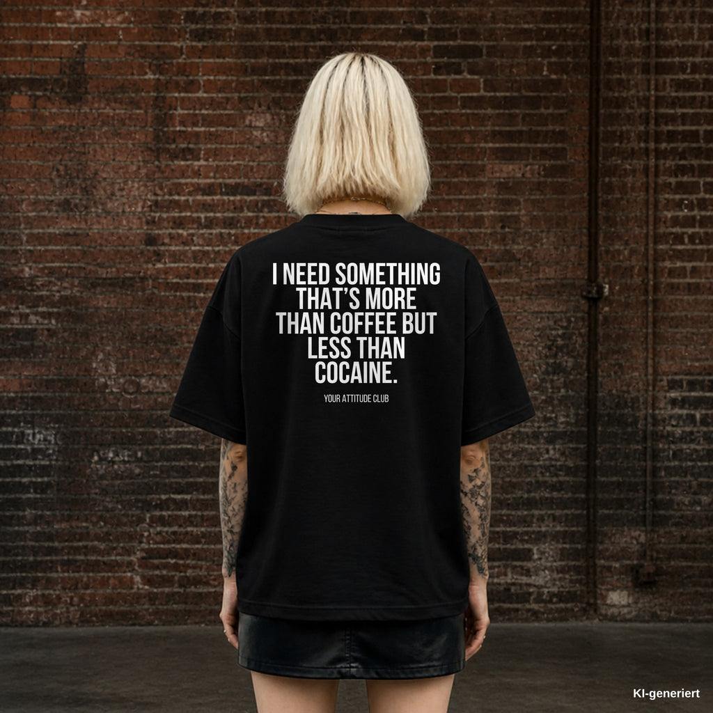 I NEED SOMETHING THAT’S MORE THAN COFFEE BUT LESS THAN COCAINE. – schwarzes Oversize T-Shirt mit weißem Backprint, Damen