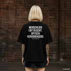 MENSCHLICH ENTTÄUSCHT. OPTISCH HERVORRAGEND. – schwarzes Oversize T-Shirt mit weißem Backprint, Damen