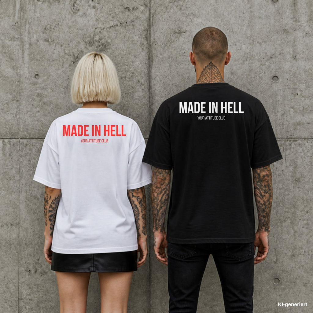 MADE IN HELL – Oversize Shirt mit Spruch auf dem Rücken, Paar in Weiß und Schwarz vor Betonwand