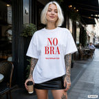 NO BRA – weißes Oversize T-Shirt mit rotem Frontprint, Damen im Straßencafé